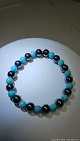 Photo of a stretchy bracelet composed of alternating natural robin's egg blue turquoise and metallic hematite round beads, 8mm and 6mm sizes.
