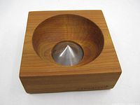 Top view showing circular cavity and stainless steel cone filter inside cherry wood block