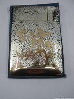 Front of case showing floral tree design and lighter corner