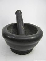 Mortar with pestle resting inside, showing overall form