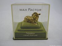 Front view of Max Factor Aquarius zebra perfume compact in clear display box