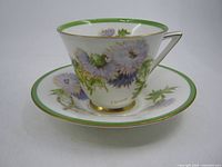 Teacup on saucer showing pattern, trim and overall condition