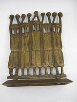 Front view showing nine human figures forming candle holders