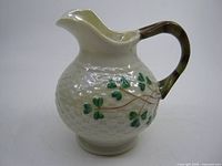 Side view of cream jug showing shamrock motif and basket weave texture