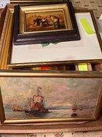Three framed wall art prints stacked including small wood relief artwork, a floral print, and a marine scene painting.