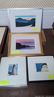 Overview of four framed artworks arranged on table