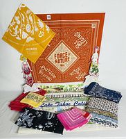 Photo showing a variety of folded and displayed bandanas with different nature-inspired prints and colors.
