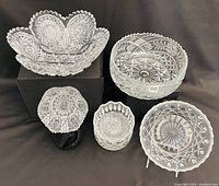 Full group image showing all six assorted crystal and cut glass pieces, varying in size and shape, arranged on black background.