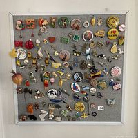 Full view of cork display board with extensive pin collection arranged in rows including Christmas, animals, food, teaching, and other themes.