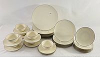 Full view of the complete Lenox china set including stacked dinner plates, salad plates, bread plates, and cup and saucer sets shown on a plain background.