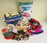 Full view of the sewing notions lot showing fabric, stuffing, ribbons, buttons, thread and pins