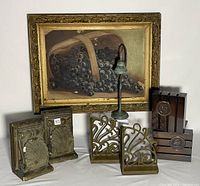 Frontal photo showing entire lot including the painting, three different sets of bookends (metal shell motif, brass scroll design, dark rectangular with medallion) and the green patina Camino Real desk bell.