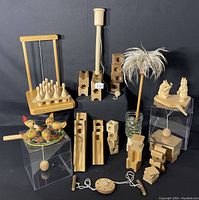 Full view of the handmade wooden toys collection including marble maze blocks, painted spinning tops, wooden bowling pins, balancing toys, decorative wooden figurines, and the emu feather duster.