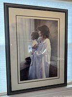 Full view of the framed print showing the woman holding a baby.