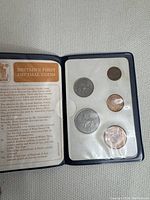 Full set of five Britain's first decimal coins in original presentation folder, with text explaining the coin designs and history.