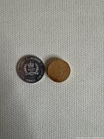 Two Canadian coins side by side on a textured light fabric surface, showing size and color difference between commemorative silver Jubilee and bronze 5 cents coins