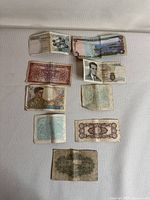 Overview of all 9 international currency bills laid flat for condition and design inspection.
