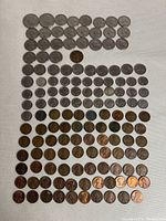 Full layout image showing an arrangement of 90 American coins in multiple rows, including pennies, nickels, dimes, quarters, and half dollars, with different wear and patina.