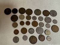 Full display of the lot showing all coins in various sizes and conditions on a light fabric background