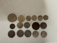 Overview of 16 UK coins showing a variety of denominations and designs from different years