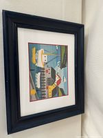 View of entire framed print showing harbor scene with boats, docks, and buildings in vibrant folk art style.