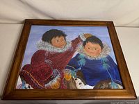 Framed painting showing full view of two children in winter clothing.