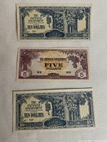 Three WWII Japanese banana money notes laid out: two $10 bills in blue-green and one $5 bill in brown shades, on textured light background.