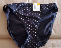 Photo showing front of black bikini underwear with white polka dots and tag attached