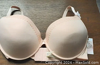 Front view of light pink molded bra with smooth cups and lace trim on upper edges.