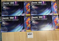 Four boxes of Sonic 100 nitrile medical examination gloves, XL size, stacked and showing front labels.