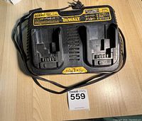 Top view of DEWALT dual battery charger showing two battery slots and attached power cord with taped section