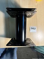 Side view of black metal boat seat swivel pedestal mount showing top and bottom mounting plates.