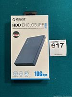 Factory sealed ORICO HDD enclosure in original retail packaging showing front with product image and branding.
