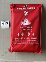 Full view of the red fire blanket pouch with printed instructions, size, and certification details.