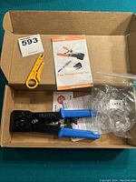 Top view of box showing crimping tool, yellow stripper, Cat 6 cable ends, and instruction manuals.