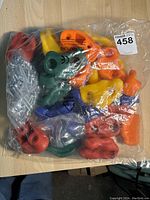 Plastic bag of multicolored rock wall climbing grips with mounting hardware underneath.