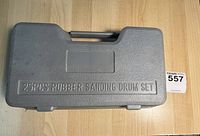 Closed gray hard plastic carrying case labeled '25PCS RUBBER SANDING DRUM SET'.
