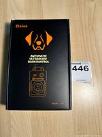 Front view of Zlolen black box with orange illustration and text of the ultrasonic bark controller device.