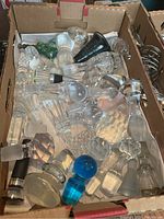 Box of assorted glass stoppers showing variety of shapes and finishes