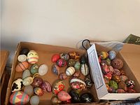 Overview of multiple decorative eggs in cardboard box