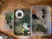 Top view of three containers with assorted flower frogs in glass, metal, and plastic