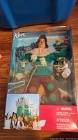 Photo of the Ken doll packaged as the Scarecrow character with visible Wizard of Oz logo and other characters.
