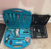 Two tool sets open and displayed on floor, showing all included tools and cases