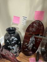 Photo shows both the Korean enamelled vase and the Japanese lacquer panel side by side, with visible mother of pearl inlay details and the tags with lot information.
