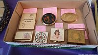 Full view of 7 vintage items arranged in a box with pink identification notes describing each item's size and type.