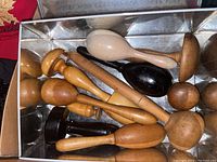 Overview of wooden sock darners in metal tin