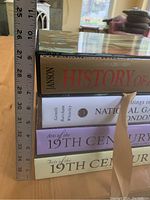 Stack of four thick art reference books measured next to a metal ruler showing approx. 27 in. height