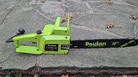 Side view of Poulan electric chainsaw showing green body and black 16 inch bar with Poulan logo.