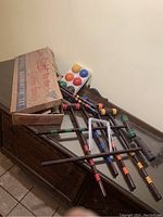 Vintage croquet set including wooden mallets with color bands, metal wickets, six painted croquet balls, and the original labeled box.