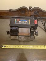 Front view of the WEN Wet Wheel electric sharpener showing whole device with ruler for size reference.